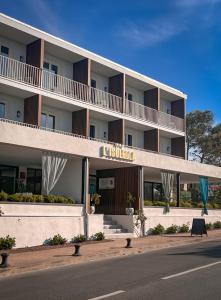 a large white building on the side of a street at Hotel l'Isolella in Porticcio