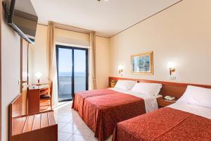 a hotel room with two beds and a window at Hotel Delle Nazioni in Milano Marittima +132 photos
