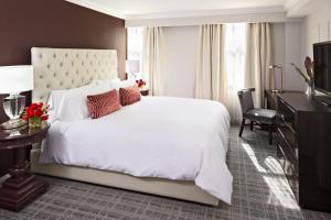 ein Schlafzimmer mit einem großen weißen Bett und einem Schreibtisch in der Unterkunft The Graham Georgetown in Washington