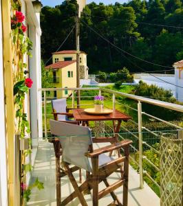 a patio with a table and chairs on a balcony at Vithos in Agnontas