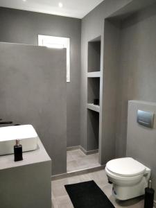 uma casa de banho com um WC branco e um lavatório. em Estia - Brand new apartment in Ermioni Village em Ermioni