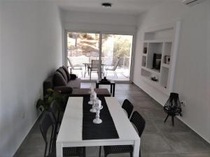 エルミオニにあるEstia - Brand new apartment in Ermioni Villageのリビングルーム(白いテーブル、椅子付)