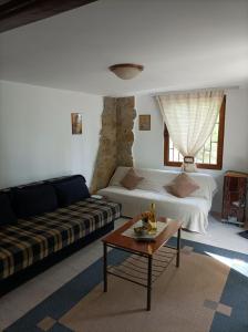 ein Wohnzimmer mit einem Sofa und einem Couchtisch in der Unterkunft Planinska kuća Bukulja in Aranđelovac