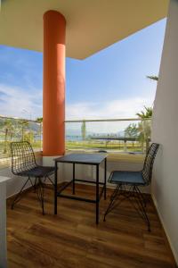 un balcone con tavolo, 2 sedie e una grande finestra di Palm Side Hotel a Vlorë