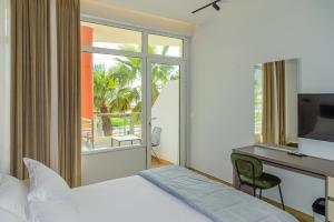 una camera con letto e scrivania con computer di Palm Side Hotel a Vlorë