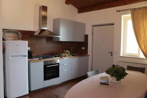 kuchnia z białą lodówką i stołem w obiekcie Agriturismo Terra dei Falchi w mieście Castilenti