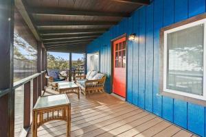 une terrasse couverte d'une maison avec un mur bleu dans l'établissement Dolphin Cove - Whole WATERFRONT House with Dock, à Ocean Isle Beach