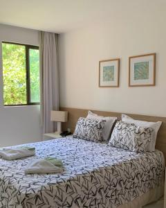 ein Schlafzimmer mit einem großen Bett mit einer Bettdecke in der Unterkunft Apartamento flat - Iloa Residence 1 in Barra de São Miguel