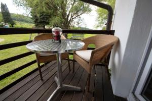 un tavolo e due sedie su un portico con tavolo in vetro di Landhotel Graf a Schliengen