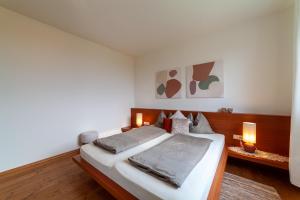 ein Schlafzimmer mit einem Bett mit zwei Leuchten in der Unterkunft Apartment Vitus in Tscherms