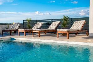 a row of lounge chairs next to a swimming pool at Villa Ajlin mit privatem beheizbarem Pool in Medulin