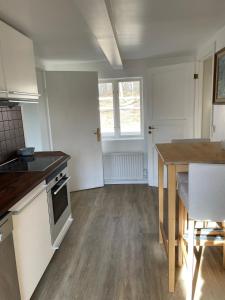 a kitchen with a wooden table and a dining room at Grindhuset in Skottorp +14 photos