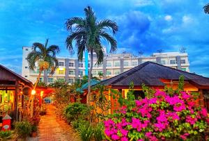 珍南海灘的住宿－Langkapuri Resort Langkawi，一座棕榈树和粉红色花朵的建筑