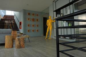 Eine gelbe Puppe steht im Wohnzimmer in der Unterkunft Bonita Bay Concept Hotel by Xarm Hotels in Santa Marta