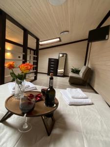 Zimmer mit einem Tisch und einer Flasche Wein in der Unterkunft Chorna Skelya Resort & Wellness in Wynohradiw