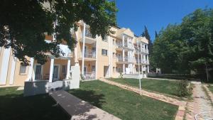 ムーラにあるMediterranean Apart Fethiyeの芝生の前に建つ大きなアパートメントです。