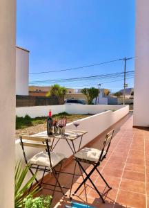 einen Tisch mit 2 Stühlen und eine Flasche Wein auf einer Terrasse in der Unterkunft Casa Lucilita in Valles de Ortega + 21 Fotos