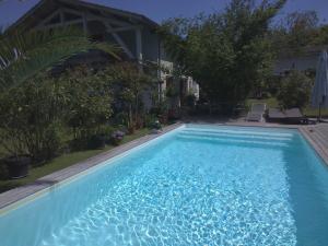 a large blue swimming pool in front of a house at Les Arums de Fondeminjean in Vertheuil-en-Médoc +5 photos