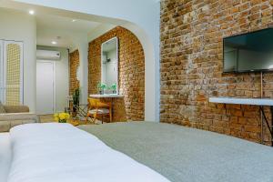 a bedroom with a brick wall with a bed and a tv at The Wilson Galata Hotel in Istanbul