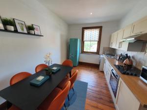 a kitchen with a black table and orange chairs at Stylish City Centre Apartment on the Kings Mile in Canterbury