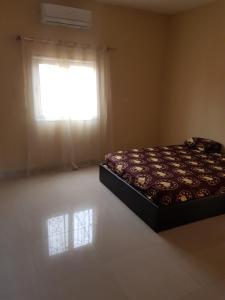 a bedroom with a bed in front of a window at Appartement Meuble AU GOLF Bamako in Bamako