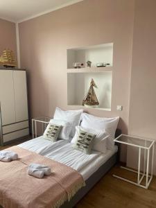 um quarto com uma cama com lençóis brancos e almofadas em Willa Andersa em Ruciane-Nida