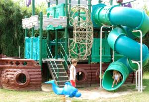 a boy and a child playing on a playground at Italian Holidays Mobile house in Ameglia in Ameglia