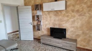 a living room with a television on a cabinet and a door at Milli in Ferrara