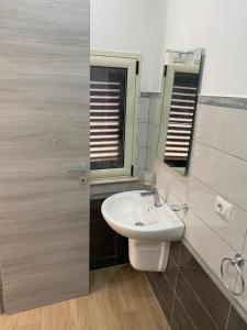 ein Bad mit einem weißen Waschbecken und einem Fenster in der Unterkunft Stanza per 2 persone da Antonio in Parghelia