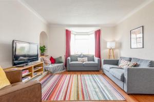 a living room with two couches and a tv at Pipeland Pad - 3 Bed - Parking - Garden in St Andrews