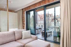 - un salon avec un canapé et une grande fenêtre dans l'établissement DEOnly Wonderland, à Gdańsk