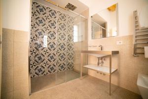 a bathroom with a shower and a sink and a mirror at Locanda Alberti in Mandello del Lario