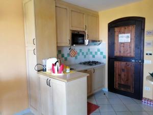 cocina con armarios blancos y fogones en Casa vacanze Calarossa (Sardegna), en Isola Rossa