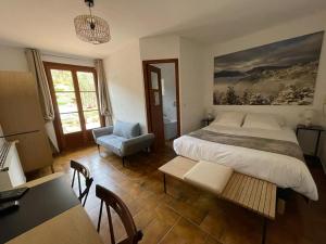 ein Schlafzimmer mit einem Bett, einem Tisch und einem Stuhl in der Unterkunft Auberge du Point Sublime in Rougon