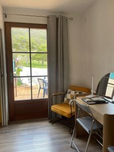 Zimmer mit einem Schreibtisch, einer Tür und einem Tisch in der Unterkunft Auberge du Point Sublime in Rougon