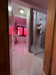 a bathroom with pink walls and a tile floor at Jánošíková chata Orava in Námestovo