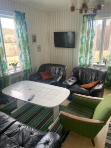 uma sala de estar com duas cadeiras e uma mesa branca em Stavred-gården em Bjärtrå