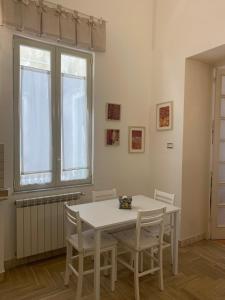 a white table and chairs in a room with a window at "Sabbinirica" in Syracuse
