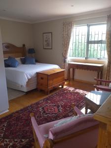 a bedroom with a bed and a couch and a window at Karoo Magic in Calitzdorp