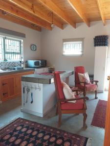 a kitchen with a counter and two chairs in a room at Karoo Magic in Calitzdorp