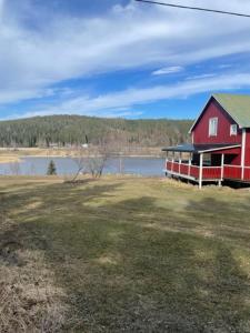 a red house next to a body of water at Stavred-gården in Bjärtrå