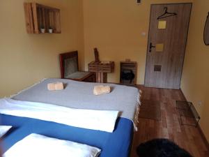 sypialnia z niebieskim łóżkiem i drewnianą podłogą w obiekcie Hostel Sielanka w Gdańsku