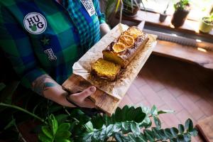 Eine Person hält ein Stück Kuchen auf einem Schneidebrett in der Unterkunft Gęsi Zakręt in Ustrzyki Dolne