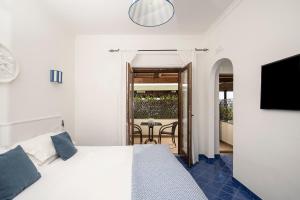 a bedroom with a bed and a balcony with a table at Monte Solaro Bed & Breakfast in Anacapri