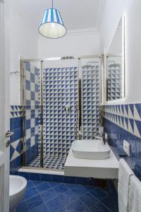 uma casa de banho azul e branca com um lavatório e um WC em Monte Solaro Bed & Breakfast em Anacapri