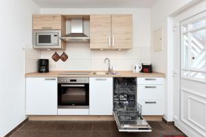 a kitchen with white cabinets and a dishwasher at Pension Pradler Wohnung 1 in Carolinensiel