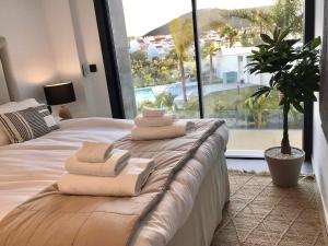 sypialnia z łóżkiem i ręcznikami w obiekcie Luxury Apartment Fernando - The View Fuengirola w mieście Fuengirola