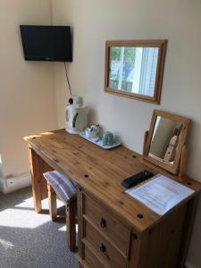 una scrivania in legno in una stanza con specchio di Giltar Grove Country House a Tenby