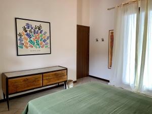 een slaapkamer met een bed, een dressoir en een raam bij Il Nido in Castelletto sopra Ticino