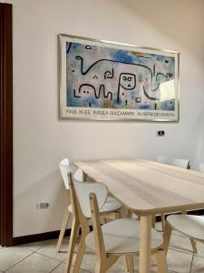 une salle à manger avec une table en bois et des chaises blanches dans l'établissement Il Nido, à Castelletto sopra Ticino